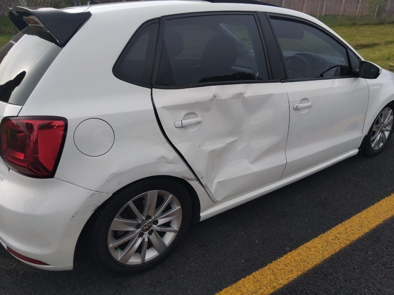 White Volkswagen Polo dented rear door before repair